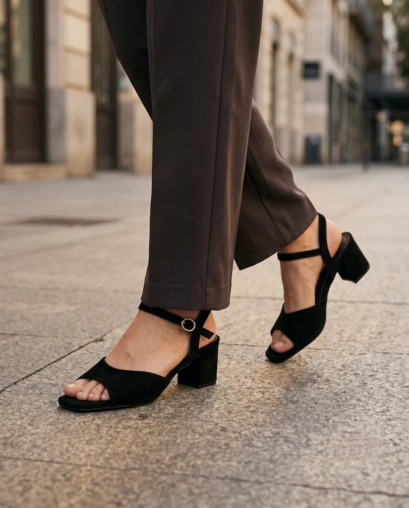 Women's black block-heel sandals with wide toe strap and ankle buckle, on-foot view