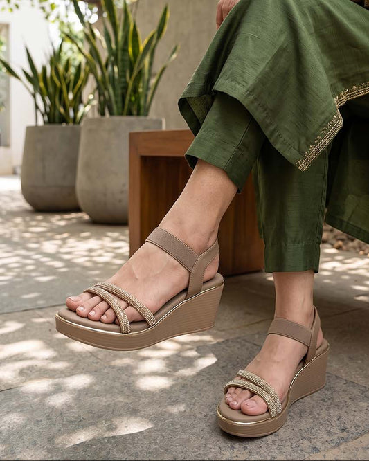 Women's beige platform wedge sandals with rhinestone arc straps and ankle strap, on-foot view